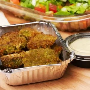 imagen de estilo de producto con una bandeja de falafel y aderezo, sobre una mesa,